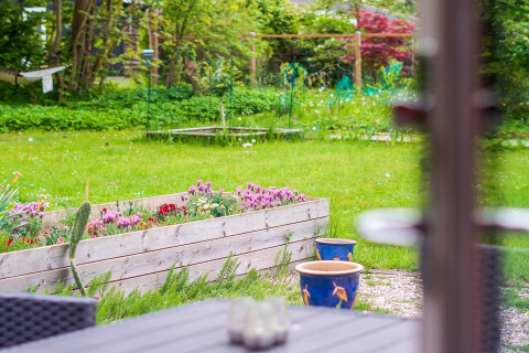 Uitzicht op tuin met bloembak en gazon bij 8-persoons vakantiehuis in Holbæk, Denemarken.
