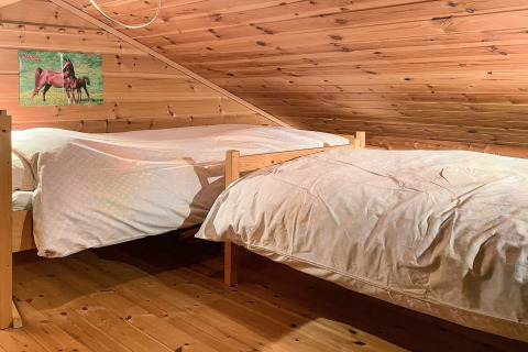 Dormitorio acogedor con dos camas individuales bajo techo de madera en casa de vacaciones en Hjelmeland.