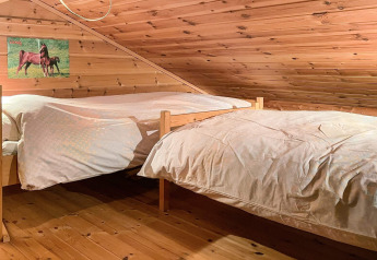 Camera accogliente in mansarda con due letti singoli e soffitto in legno in casa vacanze a Hjelmeland.