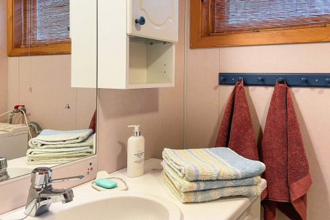 Bagno in casa vacanze a Hjelmeland, Danimarca, con asciugamani, sapone, lozione e specchio.