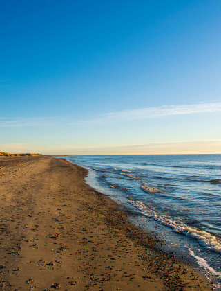 Rustig strand met zachtgolvende zee en blauwe lucht in de buurt van Horsens, Centraal-Denemarken.