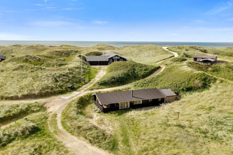 Casa sulla spiaggia Tranquil stay a Lokken, tra dune con vista sul mare e cielo azzurro limpido.