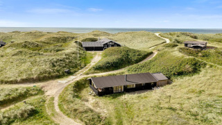 Strandhuis Tranquil stay in Lokken, omringd door duinen met zeezicht onder heldere blauwe lucht.