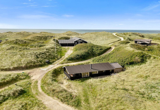 Casa sulla spiaggia Tranquil stay a Lokken, tra dune con vista sul mare e cielo azzurro limpido.