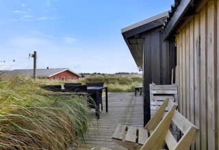 Udendørs terrasse ved strandhuset 'Tranquil stay in Lokken', med havgræs og havudsigt i Danmark.