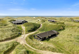 'Tranquil stay in Lokken', een strandhuis in Denemarken tussen groene duinen met uitzicht op zee.