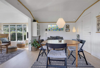 Intérieur clair et cosy d'une maison de plage à Lokken, Danemark, avec salle à manger et salon détente.