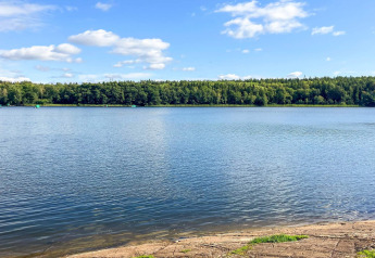 Uitzicht op een rustige meer met bomen, genomen bij Lakeside Cabin Retreat in Sollentuna, Zweden.