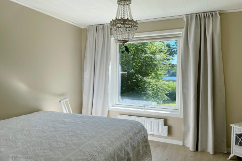 Schlafzimmer im Lakeside Cabin Retreat in Sollentuna, Schweden, mit großem Fenster und Seeblick.