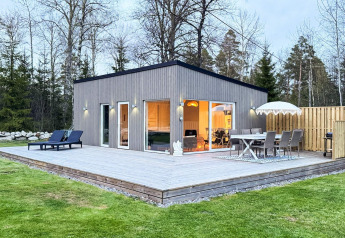 Casa de vacaciones moderna de 4 estrellas en Hestra con una amplia terraza de madera y área de jardín.