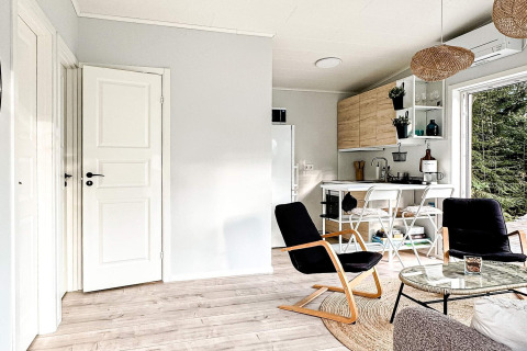 Helle, moderne Wohnküche in einem 4-Sterne-Ferienhaus in Hestra, Schweden, mit Blick ins Grüne.