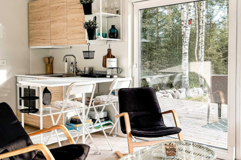Accogliente casa vacanze in Svezia con cucina moderna, salotto confortevole e vista su un bosco.