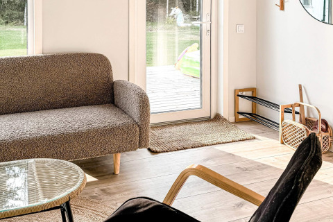 Salon lumineux et chaleureux d’une maison de vacances 4 étoiles à Hestra, Suède, avec vue sur le jardin.