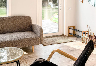 Salon lumineux et chaleureux d’une maison de vacances 4 étoiles à Hestra, Suède, avec vue sur le jardin.