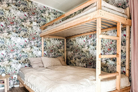 Lit superposé en bois avec lit double en bas et lit simple en haut dans une chambre de lodge à Hestra, Suède.