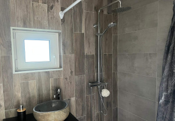 Modernes Bad in einem 4-Sterne-Ferienhaus in Hestra, Schweden, mit Dusche, Waschbecken und Fenster.