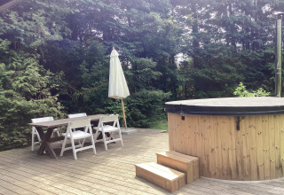 Terrasse extérieure d'une maison de vacances 6 personnes à Idestrup, Danemark, avec table et jacuzzi couvert.