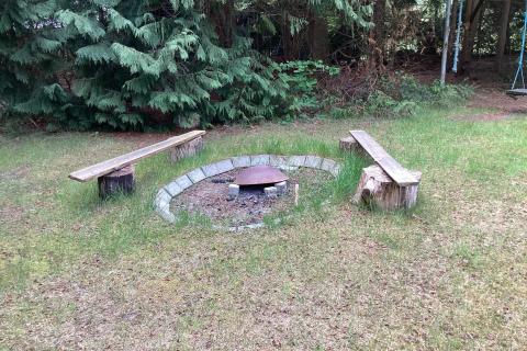 Braciere con panche in legno nel giardino della casa vacanze per 6 persone a Idestrup, Danimarca.
