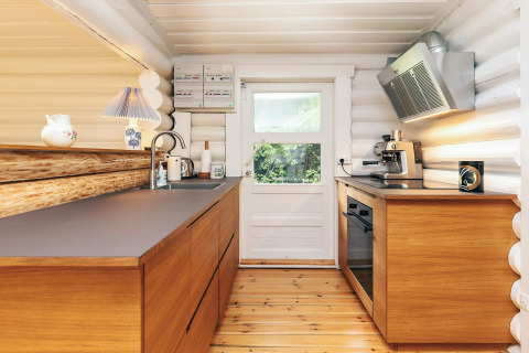Cuisine moderne avec armoires en bois, lumière naturelle et appareils intégrés à Idestrup, Danemark.