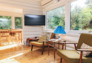 Soggiorno luminoso e accogliente di una casa vacanza a Idestrup, Danimarca, con grandi finestre e mobili in legno.