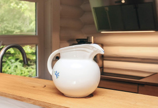 Brocca di ceramica bianca con piccolo motivo blu su piano in legno in una casa vacanze a Idestrup, Danimarca.