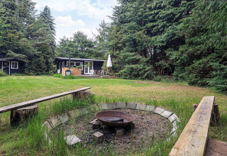 Maison de vacances pour 6 personnes à Idestrup, Danemark, avec feu de camp et bancs dans un grand jardin boisé.