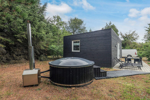 Cabaña moderna negra con jacuzzi exterior y terraza en 5-person-holiday-park-home-in-Pandrup, Dinamarca.