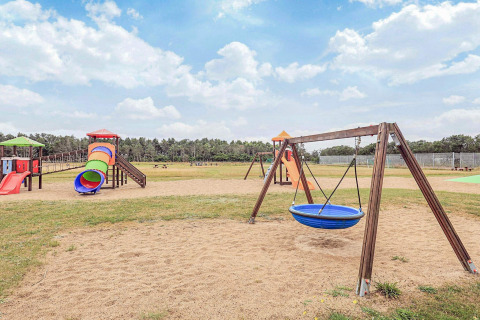 Parque infantil con columpios, toboganes y estructuras de juego sobre arena en Pandrup, Dinamarca.