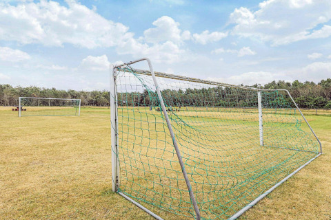 Porterías de fútbol en campo de césped junto a casa vacacional para 5 personas en Pandrup, Dinamarca.