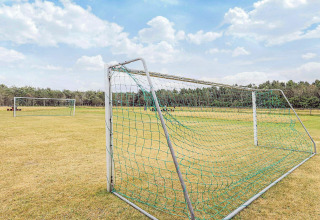 Porterías de fútbol en campo de césped junto a casa vacacional para 5 personas en Pandrup, Dinamarca.