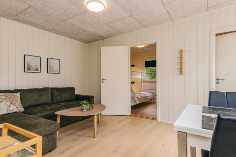 Sala de estar en una cabaña vacacional para 5 personas en Pandrup, Dinamarca, con sofá y literas.
