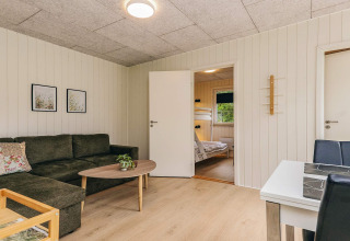Sala de estar en una cabaña vacacional para 5 personas en Pandrup, Dinamarca, con sofá y literas.