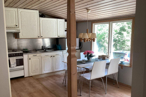Gezellige keuken en eetruimte in een vredige hut nabij het Furufjall-pad in Zweden met natuurzicht.