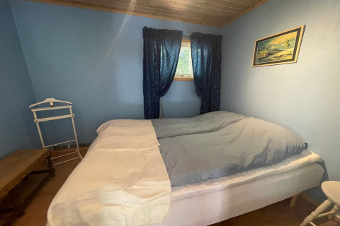 Knusse slaapkamer in de vredige cabine bij Furufjall Trail in Zweden, met blauwe muren en houten plafond.