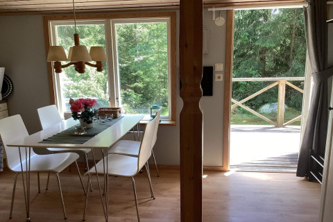 Interno di una cabina tranquilla vicino al sentiero Furufjall in Svezia, tavolo da pranzo e vista sul bosco.