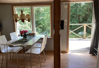 Interieur van een vredige blokhut nabij Furufjall Trail in Zweden met eettafel en zicht op het bos.
