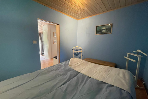 Schlafzimmer mit blauen Wänden und Holzdecke in einer friedlichen Hütte nahe dem Furufjall-Trail in Schweden.