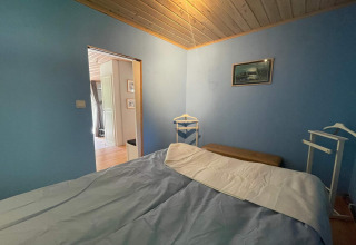 Schlafzimmer mit blauen Wänden und Holzdecke in einer friedlichen Hütte nahe dem Furufjall-Trail in Schweden.