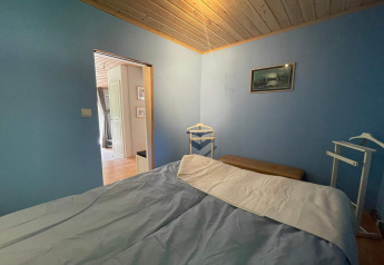 Dormitorio con paredes azules y techo de madera en una cabaña tranquila cerca del sendero Furufjall, Suecia.