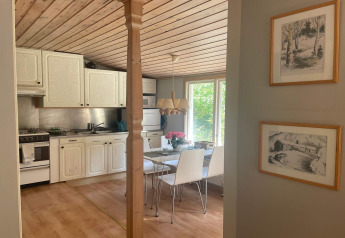 Acogedora cocina y comedor en cabaña tranquila cerca del sendero Furufjall en Suecia con madera clara.