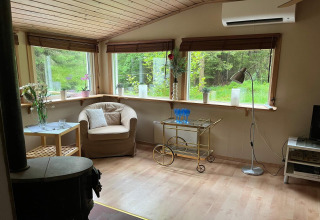 Accogliente soggiorno nella Peaceful Cabin vicino al sentiero Furufjall in Svezia con ampie finestre luminose.