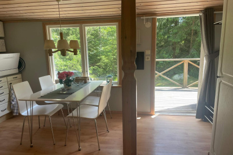 Salle à manger lumineuse dans une cabane paisible près du sentier Furufjall en Suède, vue sur la forêt.