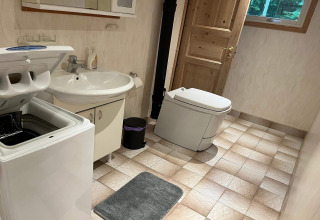 Bagno nella Peaceful Cabin vicino al sentiero Furufjall, Svezia, con lavatrice, lavandino e toilette.