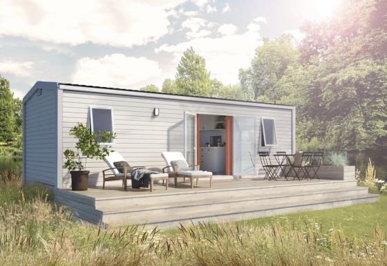 Moderne Timber Lodge bij Eurocamping Vessem BV in Nederland, met houten terras en tuinmeubilair buiten.