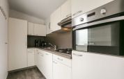 Cuisine moderne de la Lodge Mistique au Holiday Park De Lochemse Berg, Pays-Bas, avec meubles blancs et four.