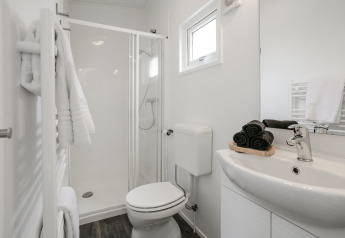 Bagno moderno con doccia, WC e lavandino al Lodge Mistique, Holiday Park De Lochemse Berg, Paesi Bassi.