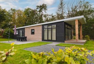 Luxe lodge bij Vakantiepark Hölte in Nederland met moderne look, terras, tuin en buitenmeubilair.