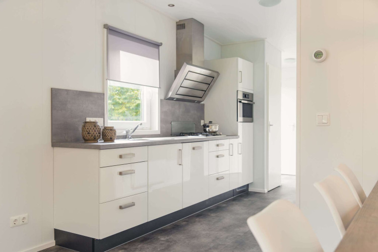 Moderne Küche in einer Luxushütte im Vakantiepark Hölte in den Niederlanden mit weißen Fronten und Geräten.