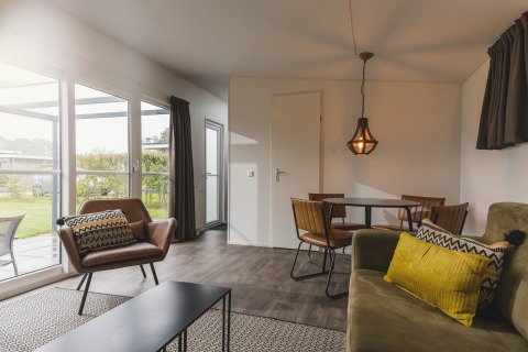 Knusse leefruimte in een Cosy Cabin op Vakantiepark Hölte in Nederland, modern ingericht met veel daglicht.
