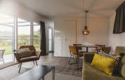 Zona giorno accogliente di una Cosy Cabin al Vakantiepark Hölte nei Paesi Bassi con arredi moderni e molta luce.